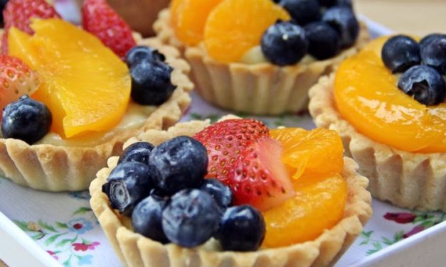 Söta tårtor med vaniljkräm, bär och frukt